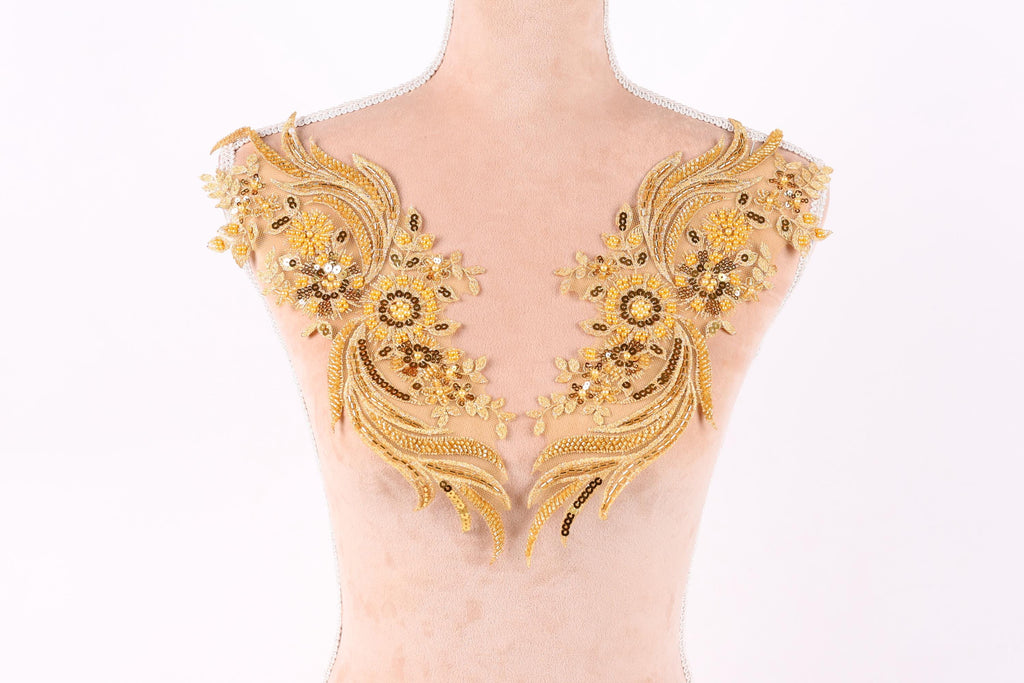 A mannequin with gold and black floral embroidered details on its shoulders.