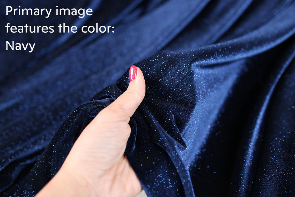 A hand holding a piece of navy blue velvet fabric, with the text "Primary image features the color: Navy" overlaid on the image.