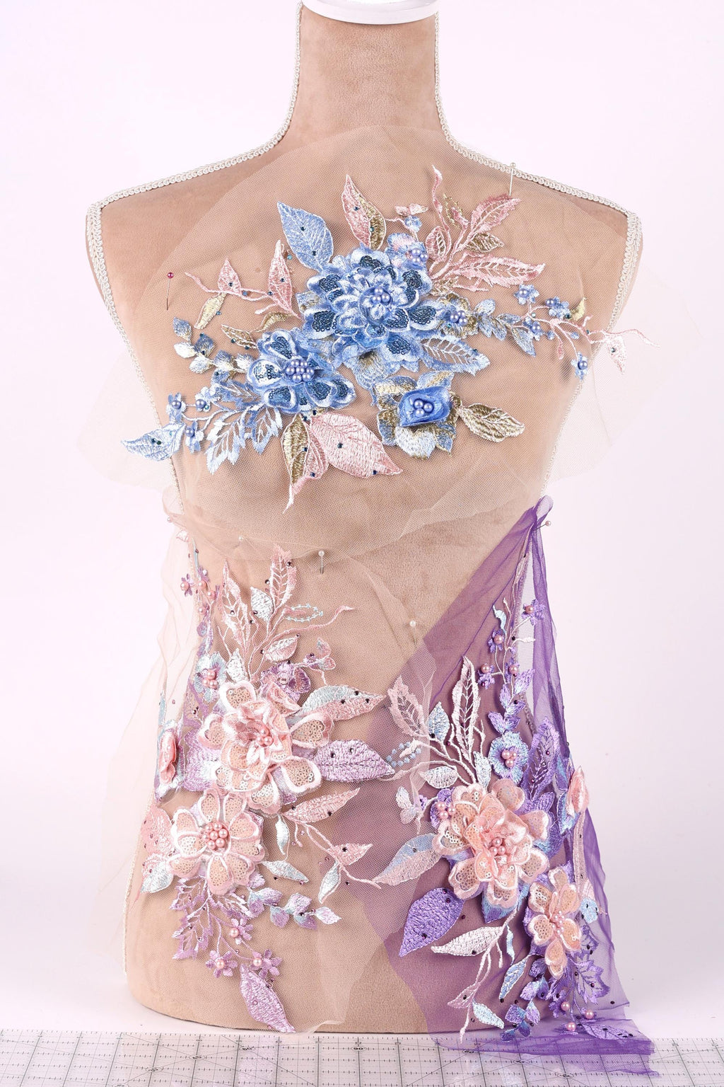 A mannequin torso wearing a dress with a floral pattern in shades of blue, pink, and purple.