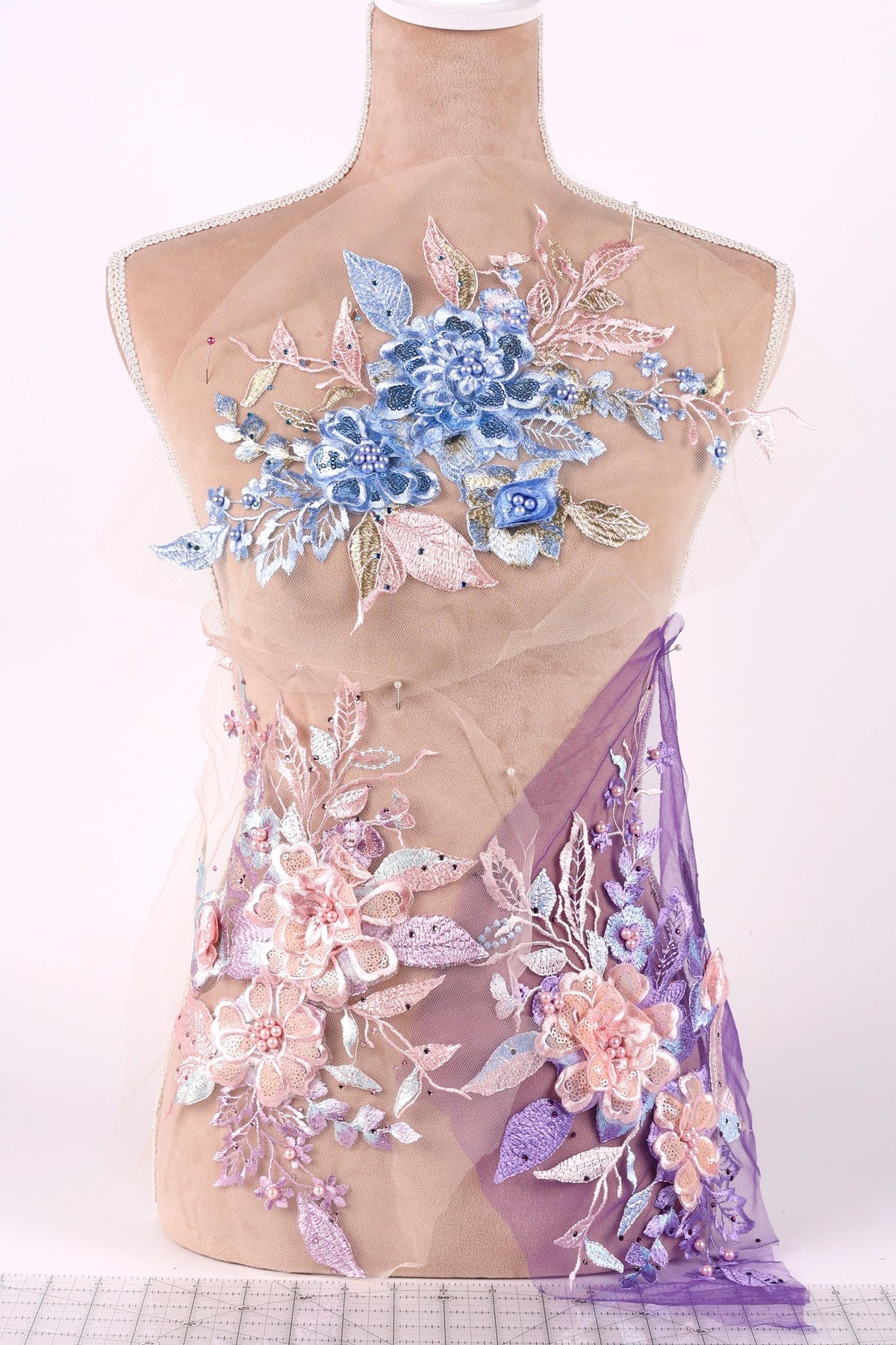A mannequin torso wearing a dress with a floral pattern in shades of blue, pink, and purple.