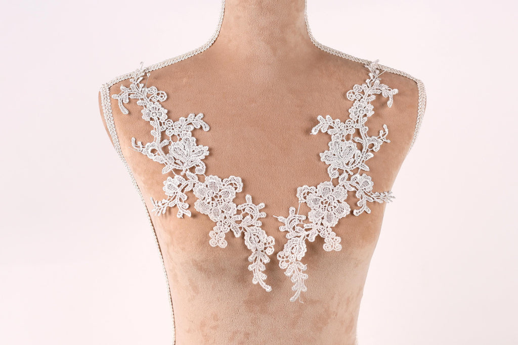 A mannequin with a delicate, lace-like design on its bust area, featuring intricate floral patterns.