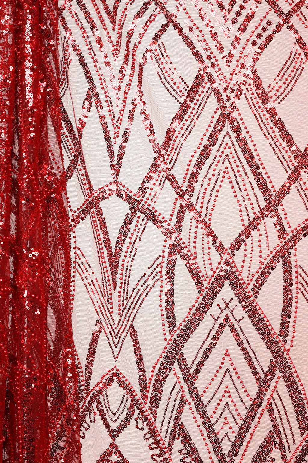 a close-up view of a fabric with a repeating pattern of red and black sequins, creating a visually striking and intricate design.