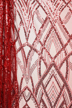 a close-up view of a fabric with a repeating pattern of red and black sequins, creating a visually striking and intricate design.