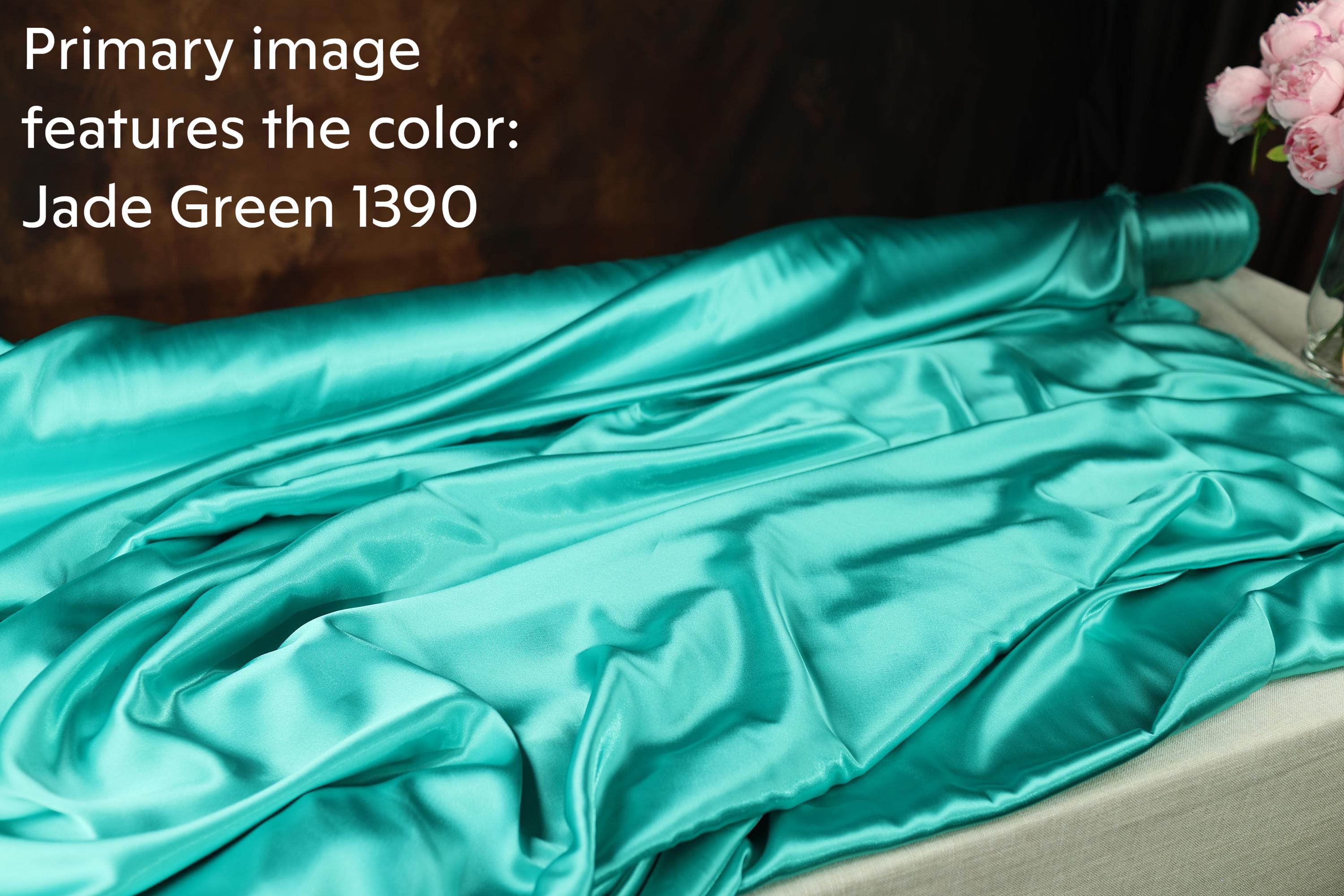 a roll of jade green silk fabric with a blurred background.