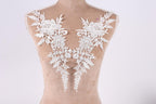 A mannequin torso with white lace fabric pieces sewn onto it, creating a decorative and elegant appearance.