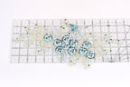a clear ruler with a floral pattern of blue and white sequins and leaves on it.