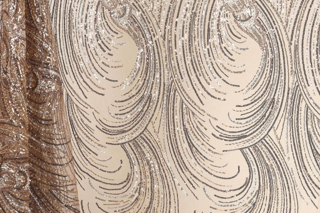 a close-up view of a fabric with a repeating pattern of swirls and lines in shades of brown and beige. The pattern appears to be made of sequins or glitter, adding a sparkly and glamorous touch to the fabric.