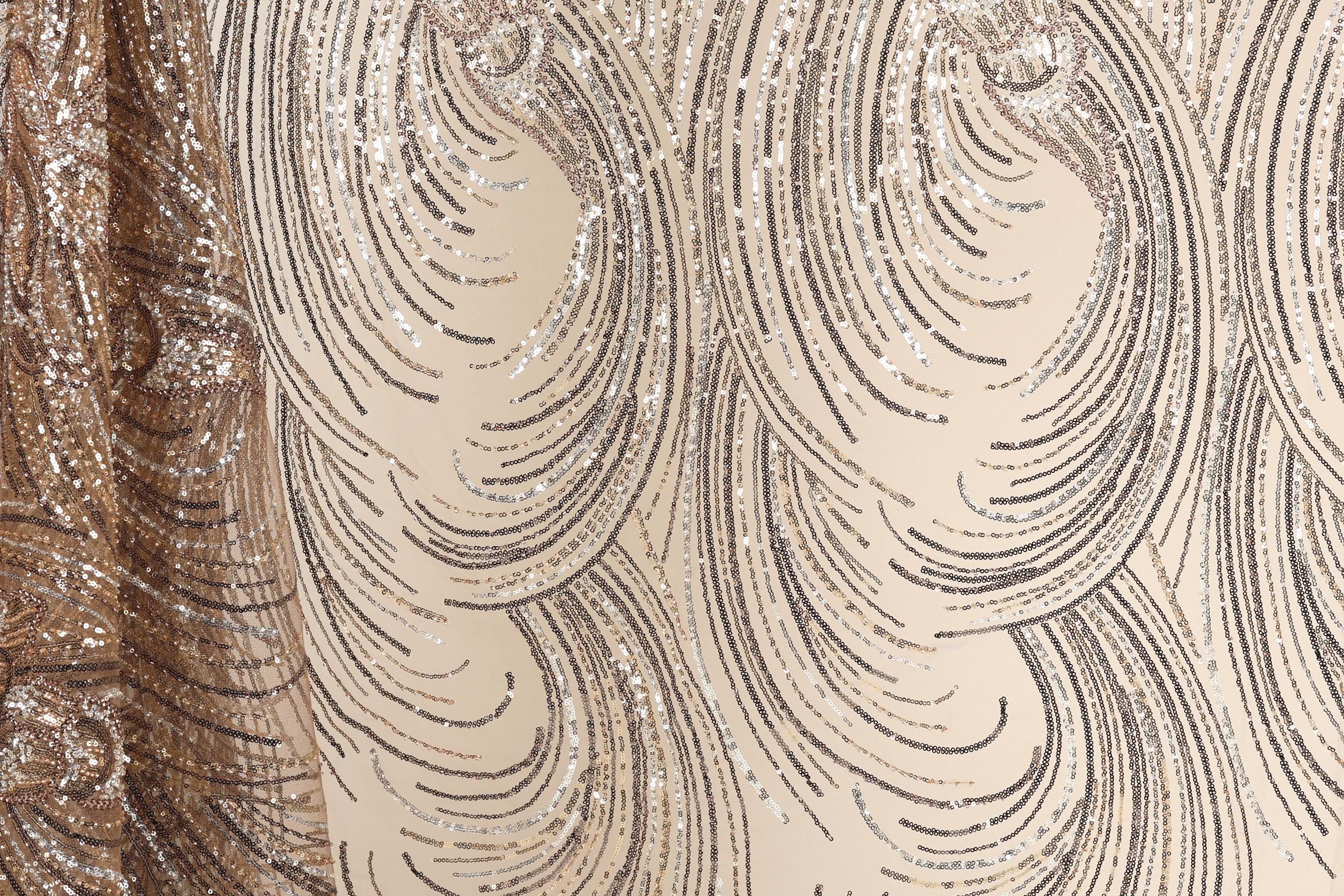 a close-up view of a fabric with a repeating pattern of swirls and lines in shades of brown and beige. The pattern appears to be made of sequins or glitter, adding a sparkly and glamorous touch to the fabric.