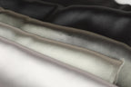A close-up image of a fabric with a variety of colors, including black, gray, and white, arranged in a layered manner.