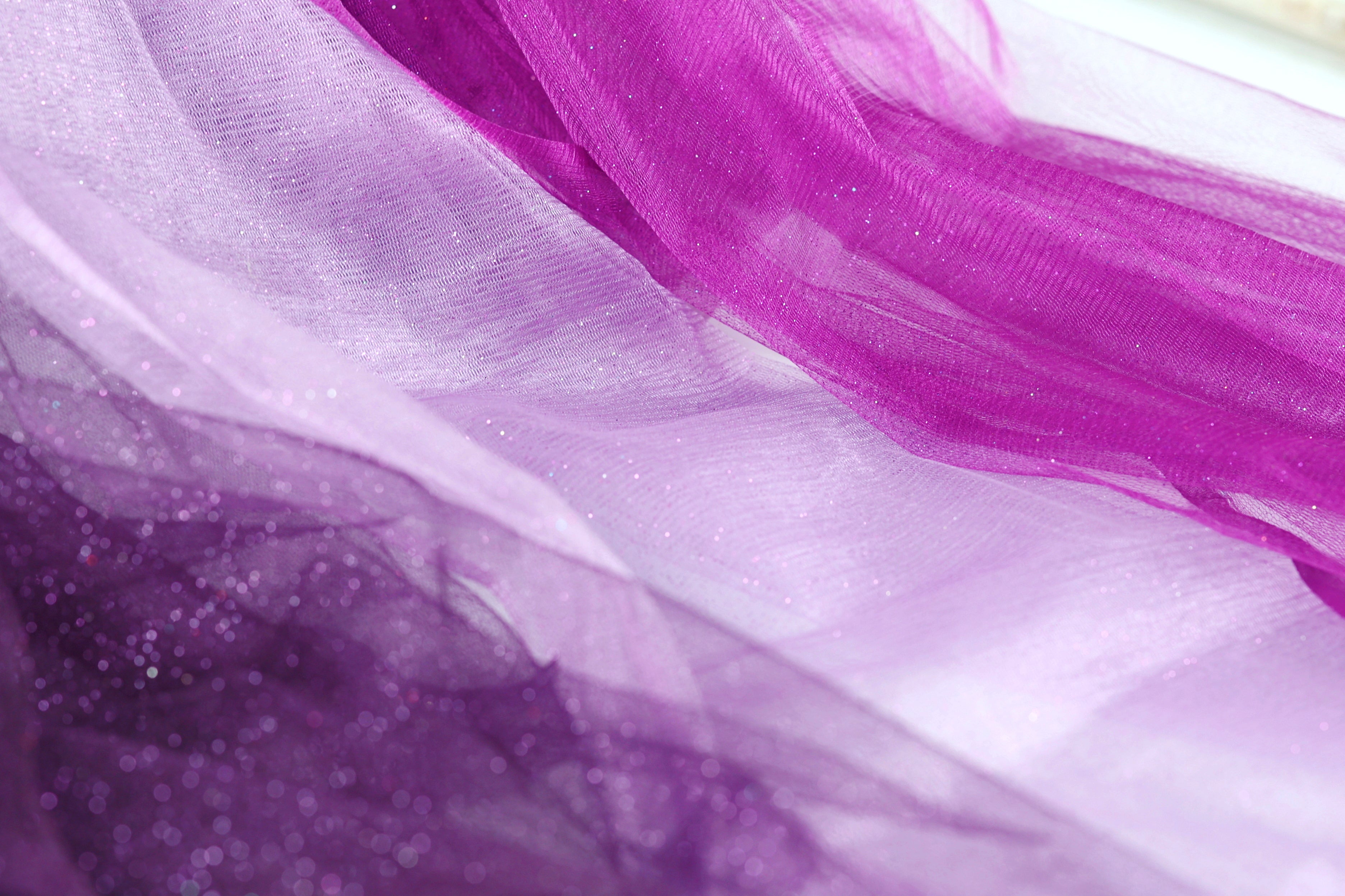 The image is a close-up of a fabric with a purple and white color scheme, featuring a mix of purple and white threads or fabric.
