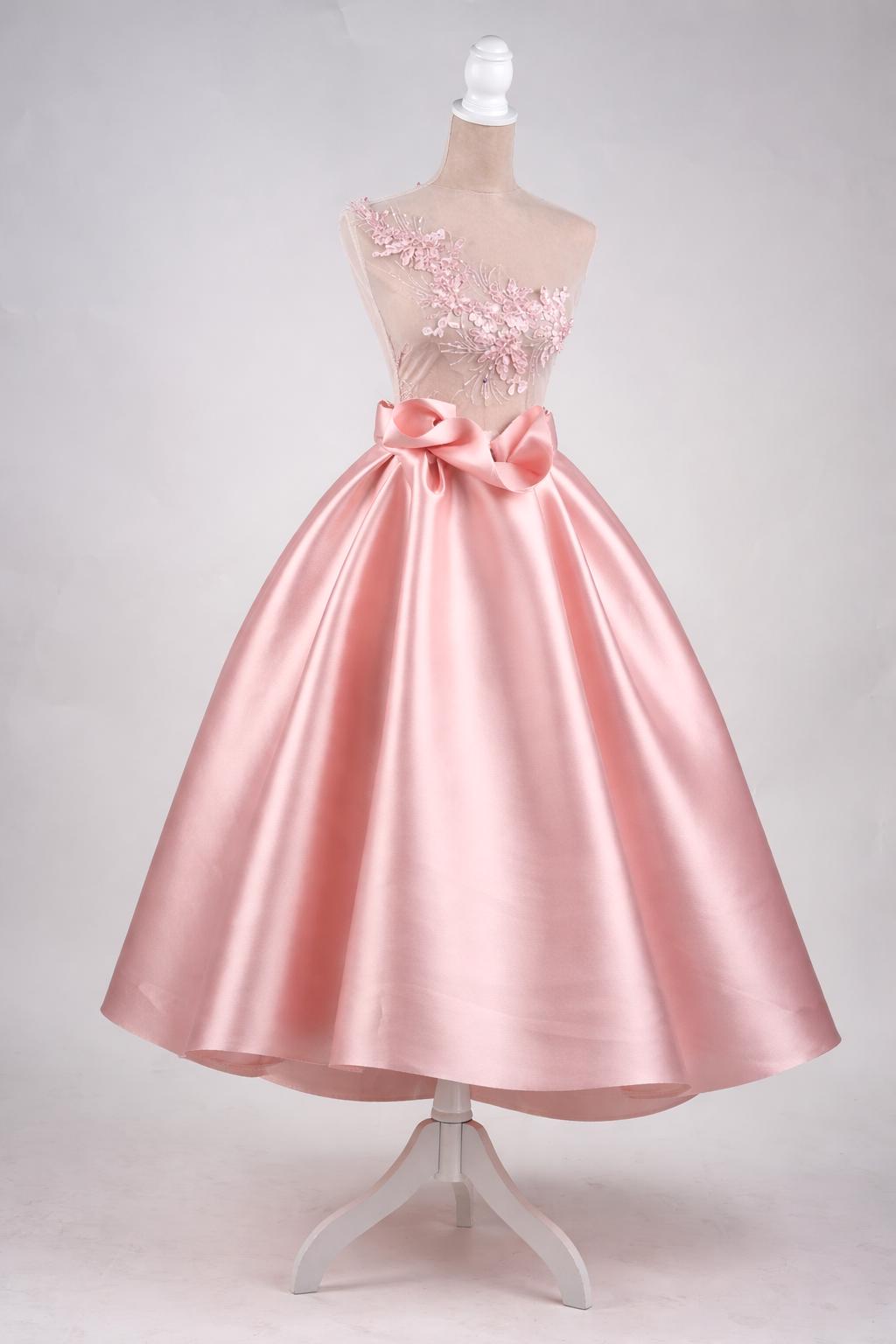 A pink satin ball gown dress with a full skirt and a bow detail on the neckline.