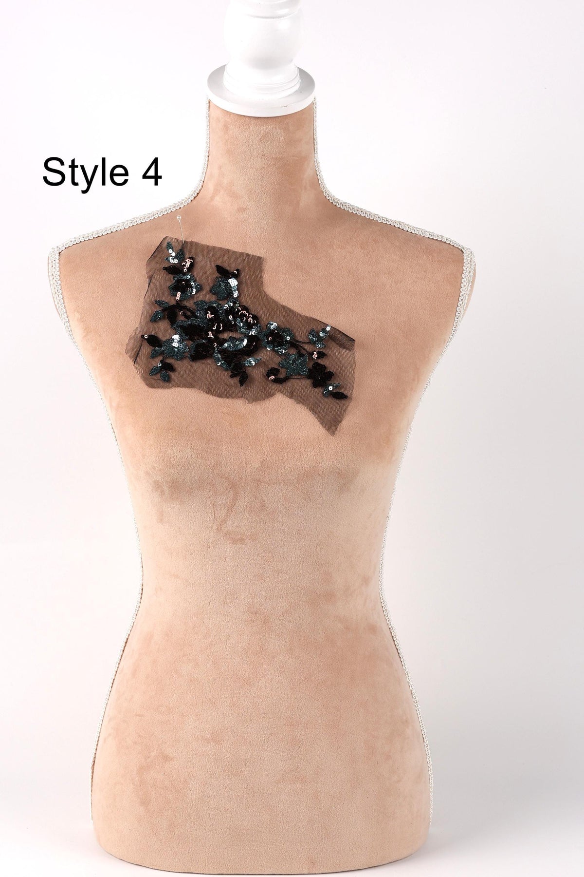 A mannequin with a beige body and a black and green fabric patch on its chest.