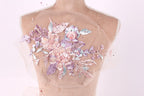 A mannequin torso with a delicate floral embroidered on it, featuring a variety of pink and purple flowers and leaves.