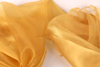 a close-up view of a piece of yellow fabric, possibly silk or chiffon, with a soft, flowing texture.