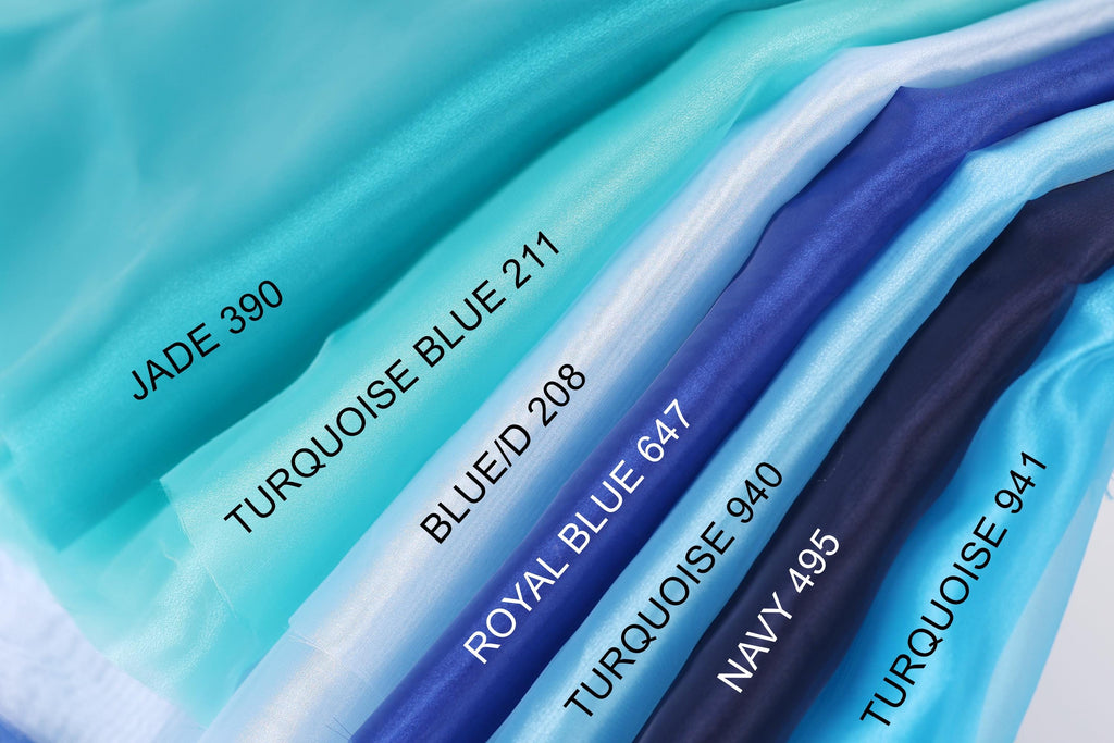 A collection of fabric swatches in various shades of blue, including turquoise, royal blue, navy blue, and turquoise, arranged in a row.
