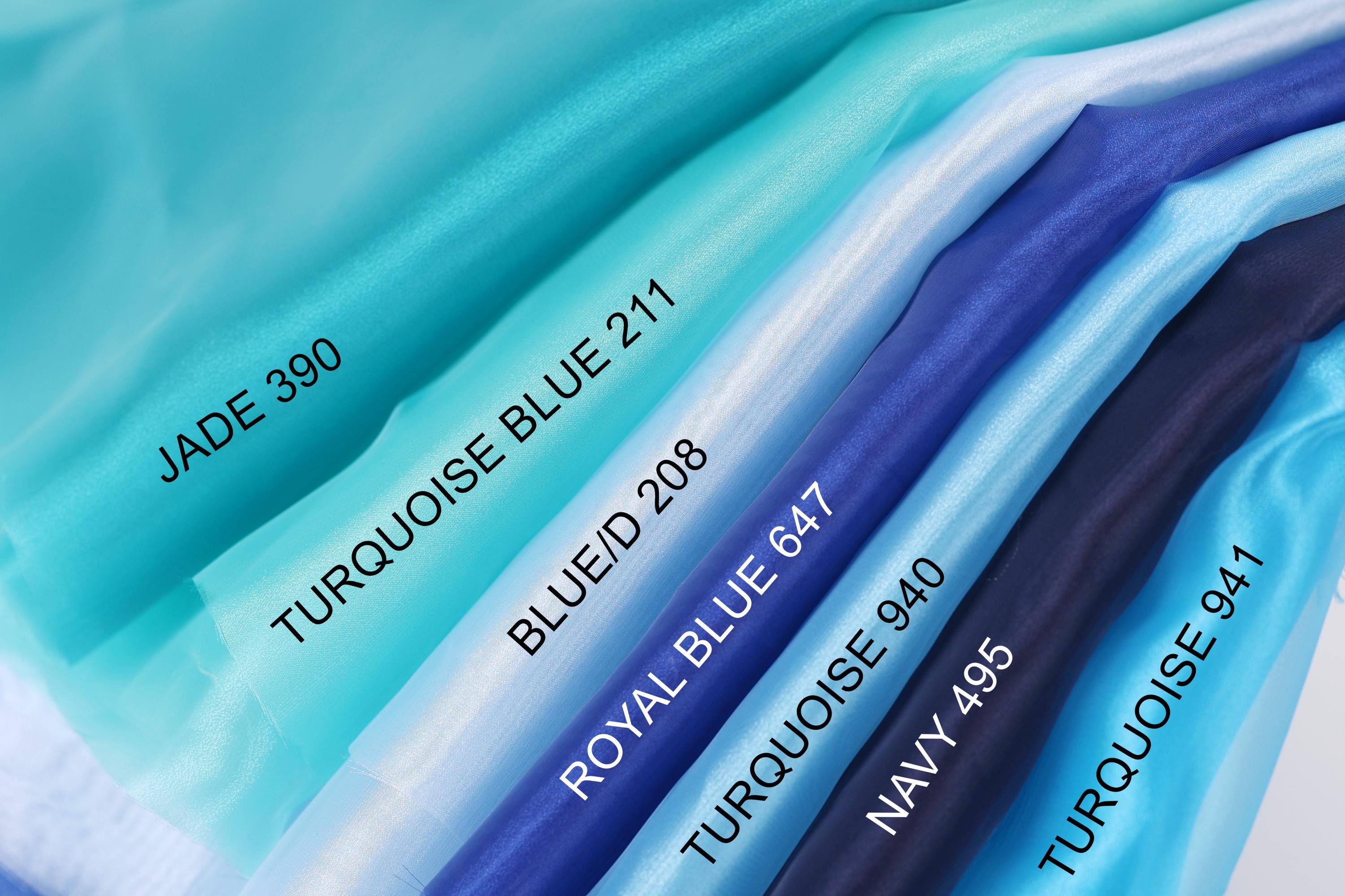 A collection of fabric swatches in various shades of blue, including turquoise, royal blue, navy blue, and turquoise, arranged in a row.