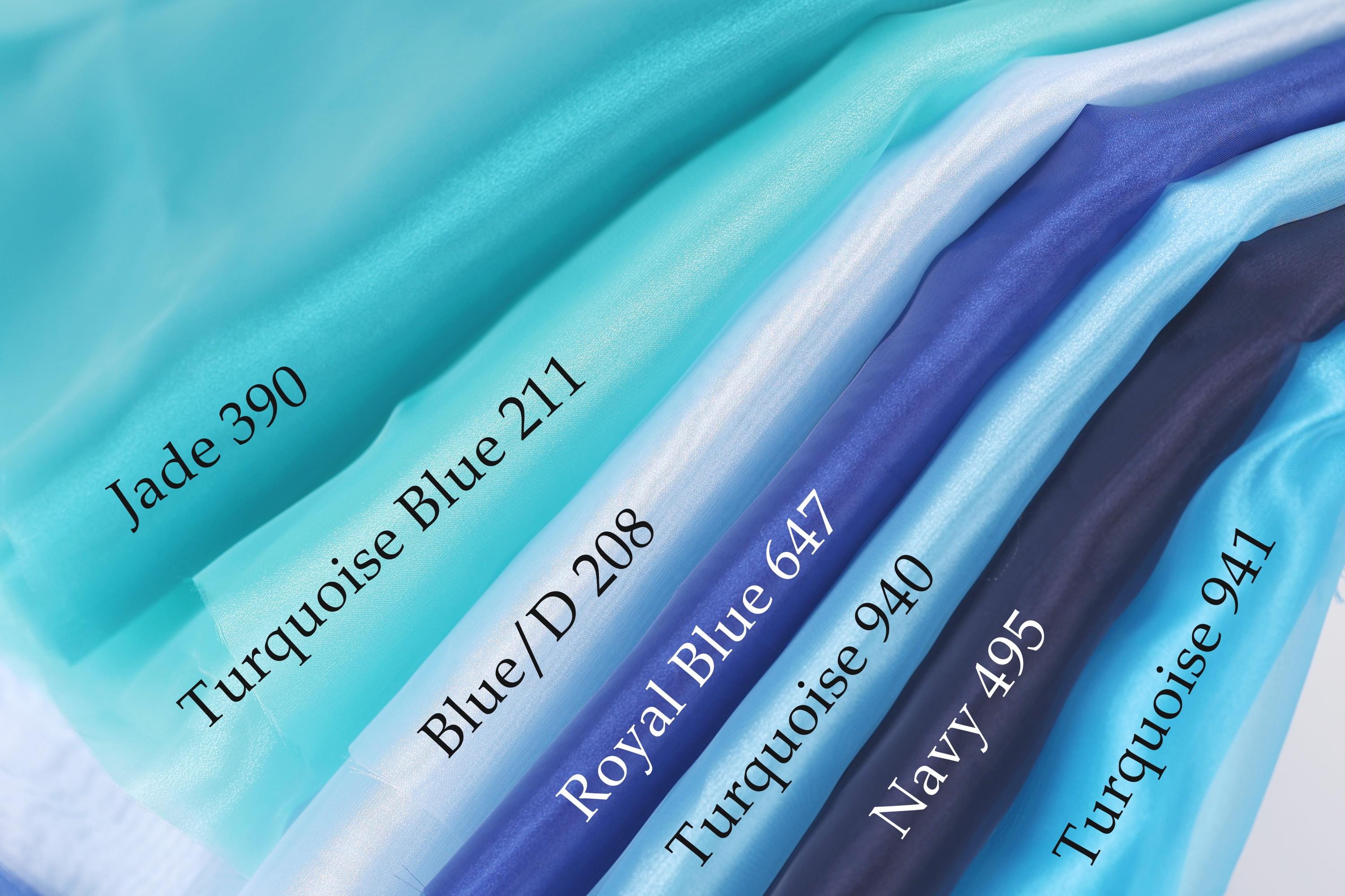 A collection of fabric swatches in various shades of blue, including turquoise, royal blue, navy blue, and turquoise/blue, arranged in a row.