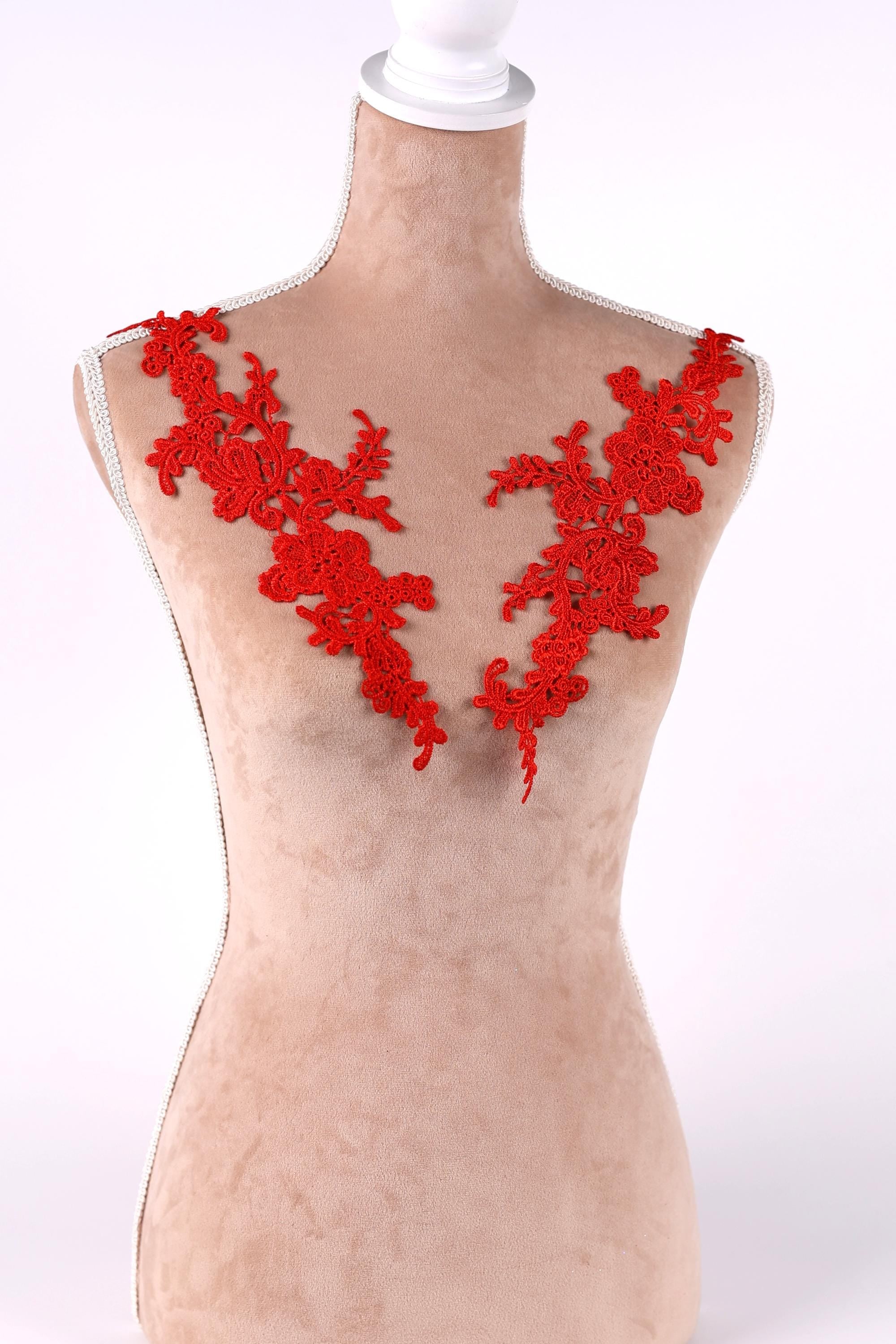 A mannequin with red floral embroidery on its shoulders.