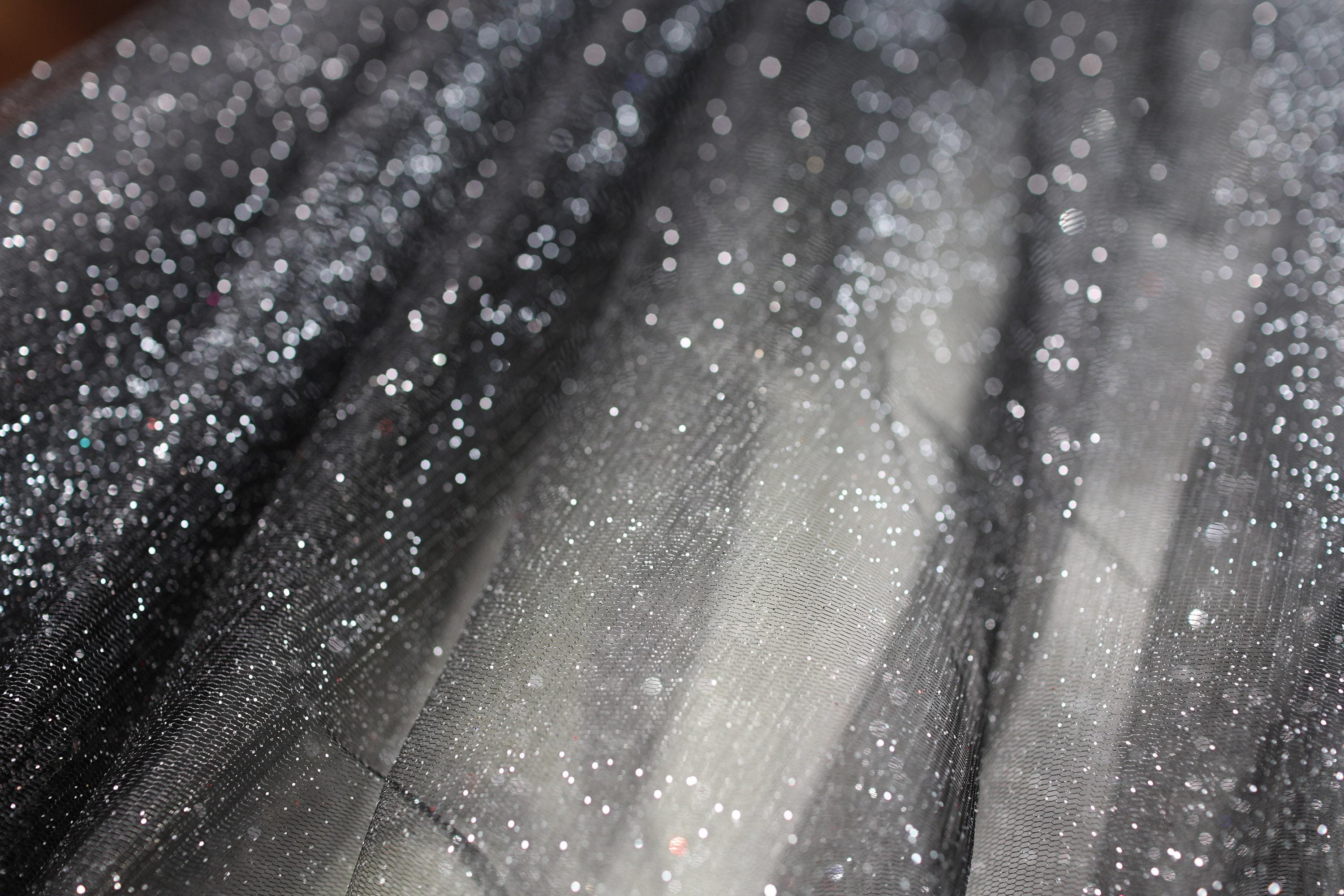 a close up of a black and white dress with silver sequins