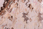The image is a close-up of a fabric with a metallic, glittery texture. The fabric appears to be a sheer material, with a pattern of small, irregularly shaped metallic elements that create a visually striking and textured appearance.