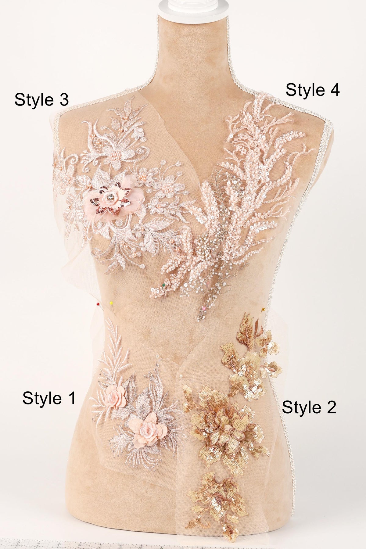 A mannequin with various decorative elements on its bust, including floral and leaf-like patterns in shades of pink and beige.