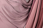 a close-up view of a fabric with a soft, flowing texture in shades of pink and red.