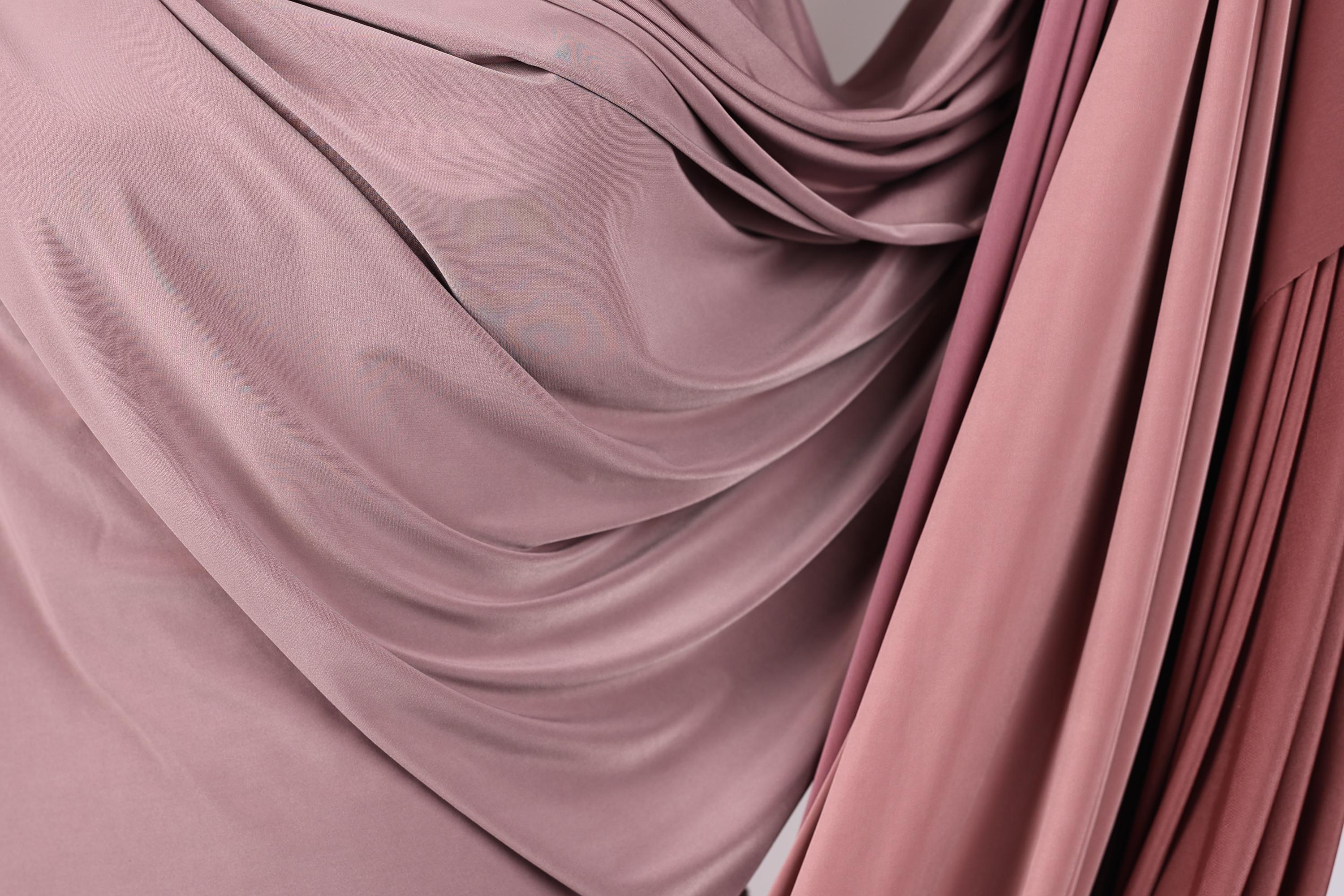 a close-up view of a fabric with a soft, flowing texture in shades of pink and red.