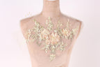 A mannequin with a delicate floral embroidered design on its bust area, featuring a variety of pink and white flowers and leaves.