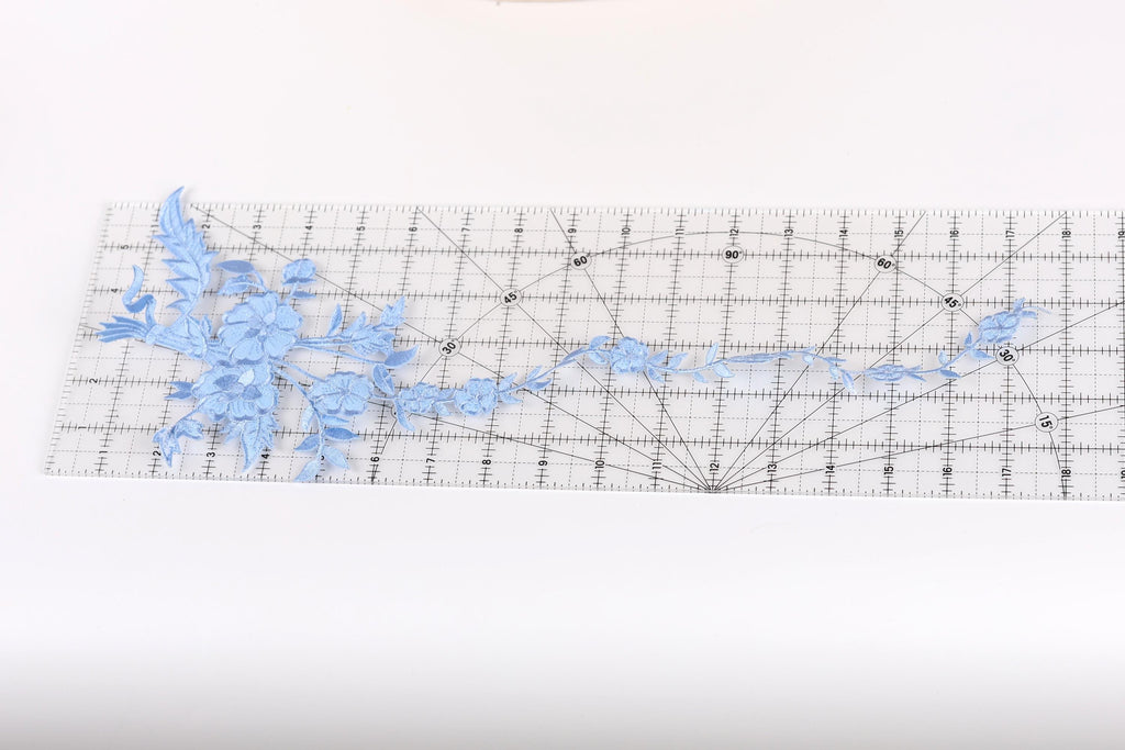 a clear ruler with a blue floral pattern on it, placed on a white surface.