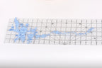 a clear ruler with a blue floral pattern on it, placed on a white surface.