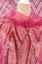 a mannequin wearing a pink sequin dress with a pink collar. The dress has a pink and black patterned design, and the sequin details are visible throughout the fabric.
