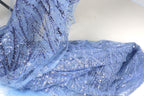 a close-up view of a piece of blue fabric with sequin details, possibly a dress or garment.