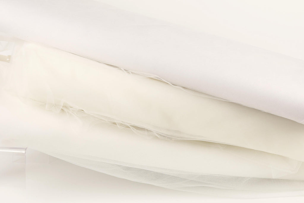 The image is a close-up of a white fabric, possibly a sheer or sheer-like material, with a slightly crumpled appearance.