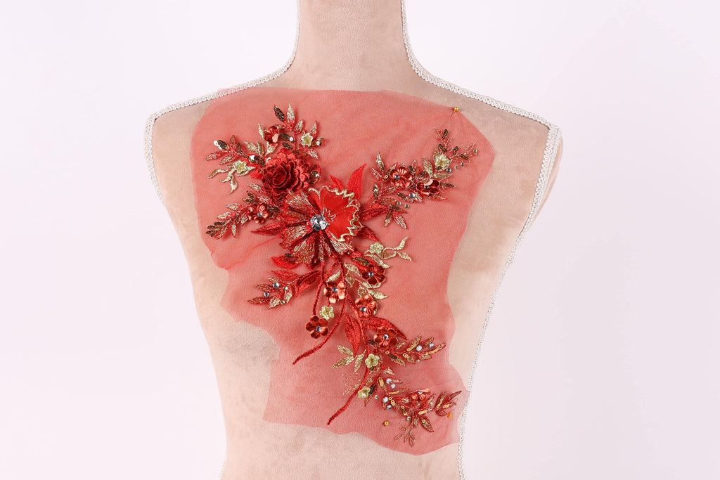 a mannequin with a red floral design on its back, featuring a variety of red flowers and leaves.