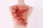 a mannequin with a red floral design on its back, featuring a variety of red flowers and leaves.