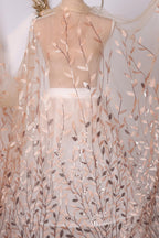 a sheer fabric with a leafy pattern, including various shades of brown and beige leaves. The fabric appears to be a sheer curtain or garment, with the leaves appearing to be embroidered or printed onto it.