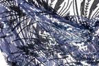 The image is a close-up view of a fabric with a pattern of blue and black sequins, creating a visually striking and intricate design.