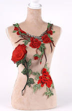 A mannequin wearing a necklace with red rose embroidery and green leaves.