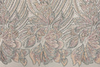 a close-up view of a fabric with a repeating pattern of pink and white flowers, as well as a repeating pattern of black and white lines. The flowers appear to be made of sequins, adding a touch of sparkle to the design. The pattern repeats across the entire fabric, creating a visually striking and intricate design.