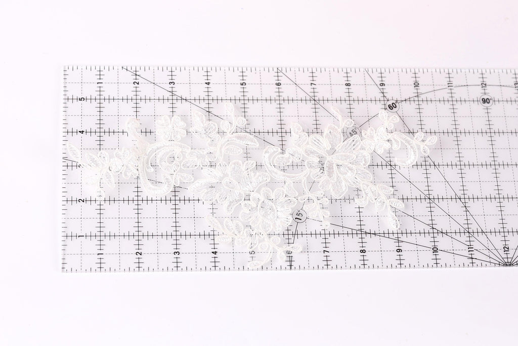 a close-up view of a transparent ruler with a white lace pattern on it.