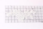 a close-up view of a transparent ruler with a white lace pattern on it.
