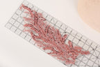 a clear ruler with a decorative pink sequin design placed on it.