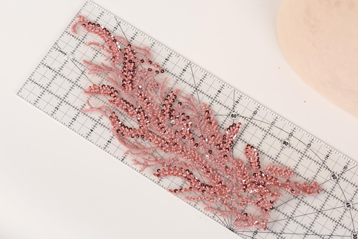 a clear ruler with a decorative pink sequin design placed on it.
