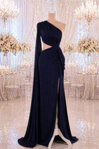 A navy blue one-shoulder evening gown with a high slit on the side, displayed on a mannequin in a room with a sparkling background.