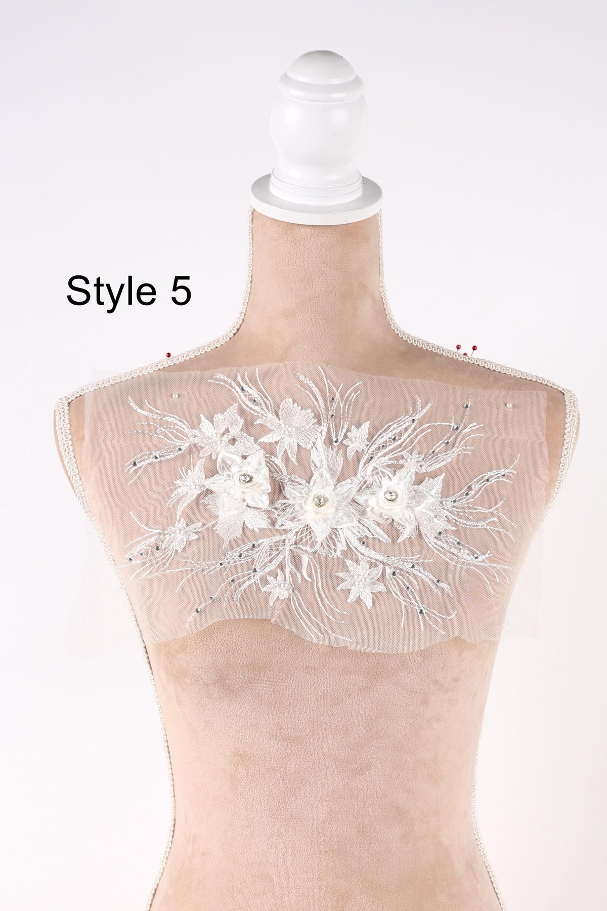 A mannequin with a white lace bodice and a floral embroidered design on the back.