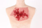 A mannequin with a red floral embroidered on its back.
