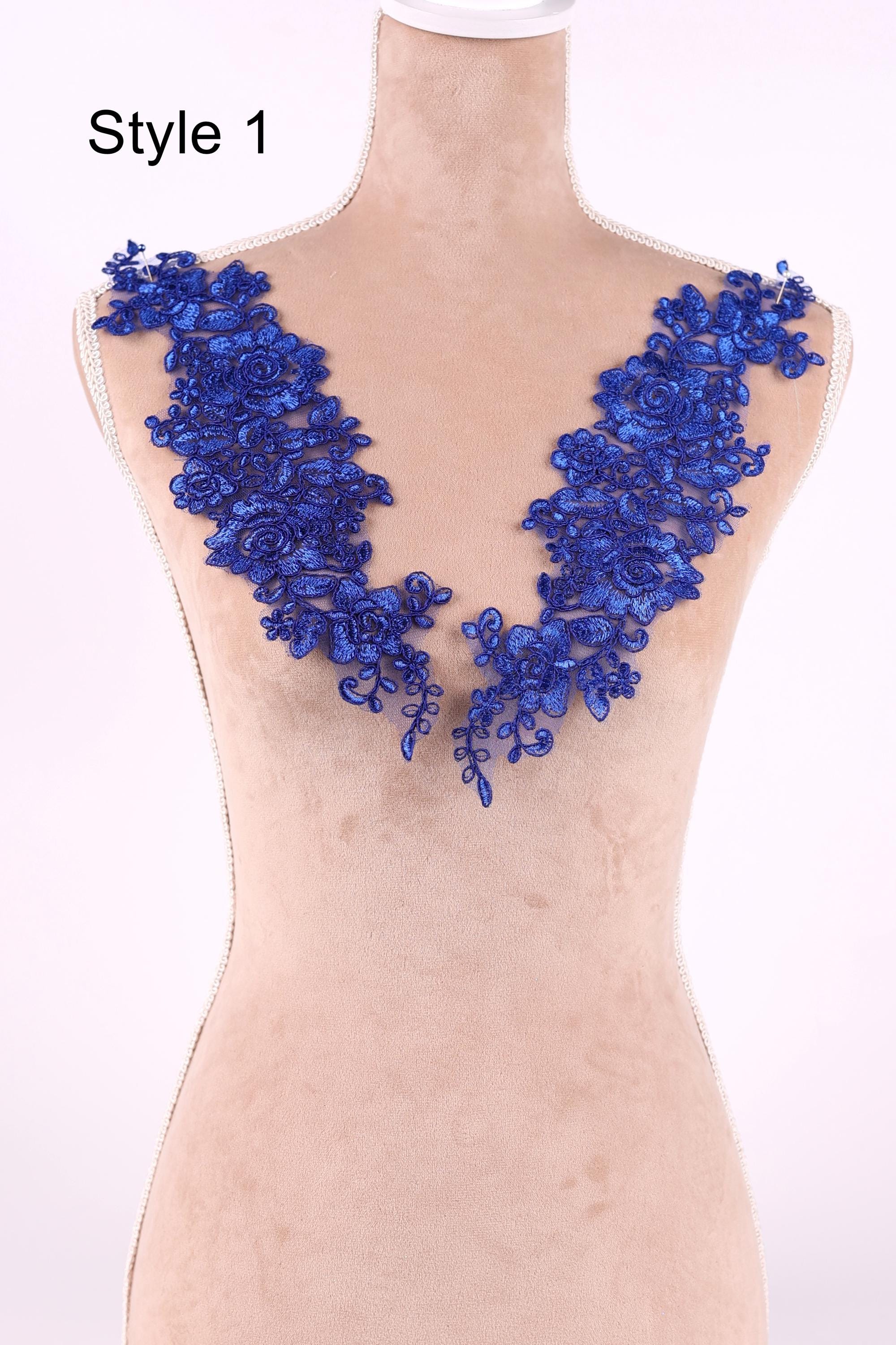 A mannequin wearing a dress with a blue floral lace overlay on the bust area.