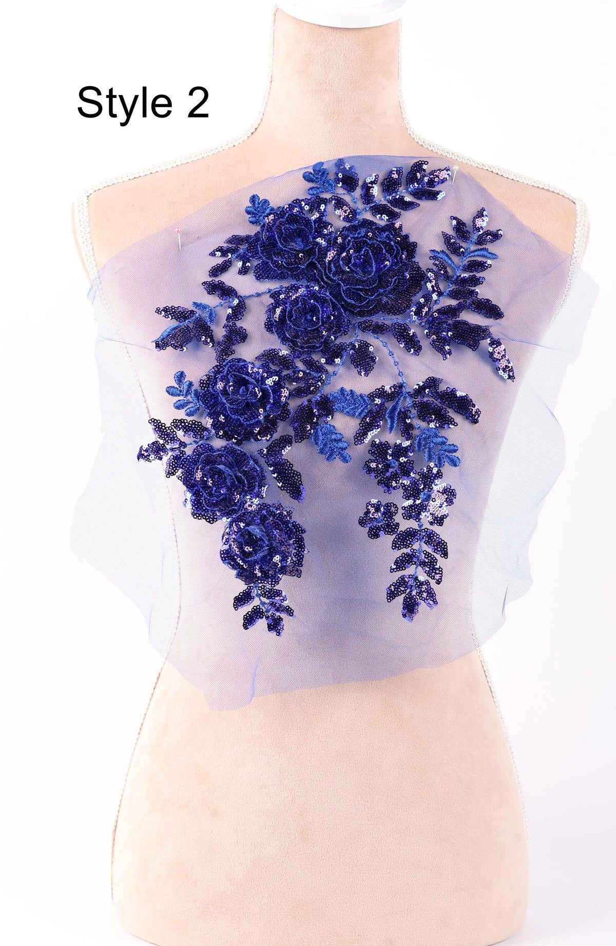 A mannequin with a sheer fabric back featuring a floral design in blue and purple colors.