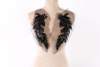 A mannequin with a beige body and black feather-like embellishments on the shoulders.