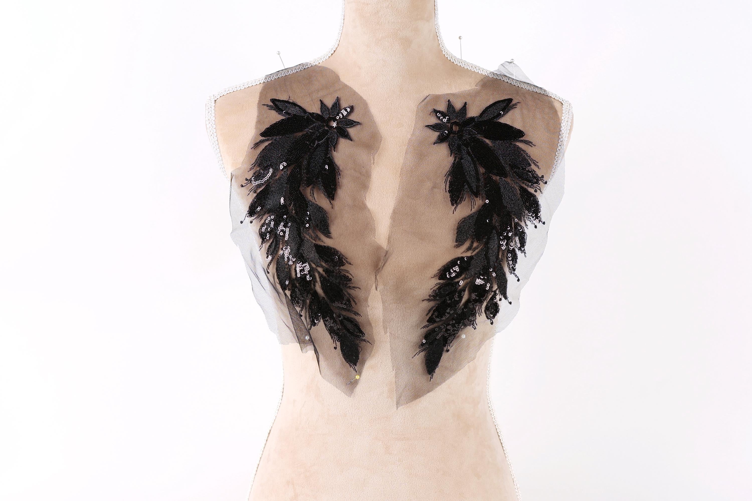 A mannequin with a beige body and black feather-like embellishments on the shoulders.